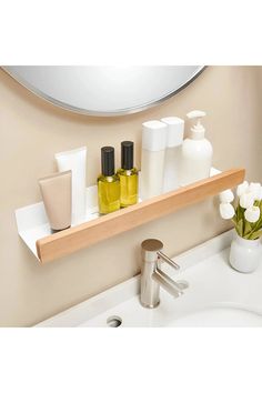 a bathroom sink with soap and lotion on it's shelf above the mirror