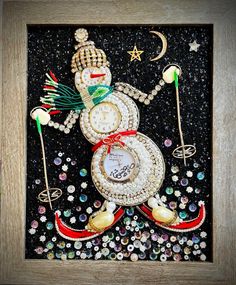 a snowman made out of beads and other items in a wooden frame on a black background