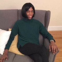 a woman sitting on top of a gray couch