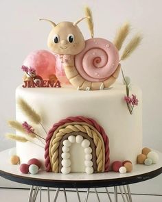 there is a cake decorated with a snail and some decorations on the top of it