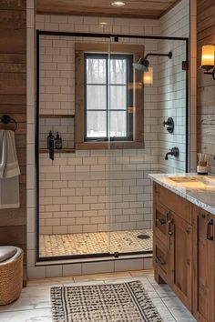 a bathroom with a walk in shower next to a sink and toilet under a window