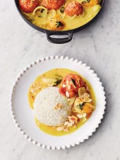 two plates filled with food on top of a white counter next to a pot and pan