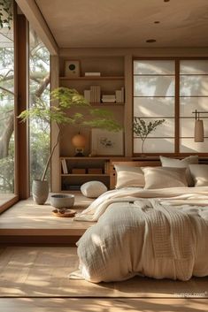 a large bed sitting under a window next to a wooden shelf filled with potted plants