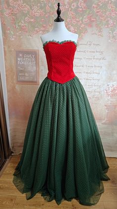 a green and red dress sitting on top of a mannequin