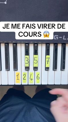 a person is holding up a piano with numbers on it and the words je me fas vivrer de cours