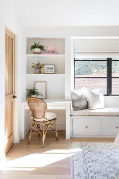 a white room with a window seat and some bookshelves on the wall next to it