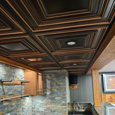 a kitchen with stone walls and wooden cabinets