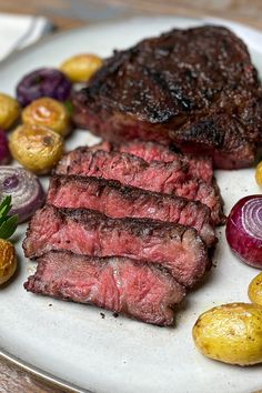 steak, potatoes and vegetables on a white plate