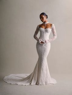 a woman in a white wedding dress with long sleeves and an off the shoulder neckline