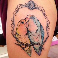 a couple of birds sitting on top of a woman's thigh next to each other