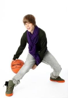 a young man holding a basketball on top of a white floor in front of a white background