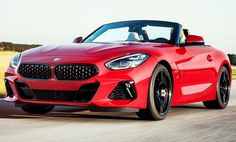 a red bmw z4 roadster driving down the road