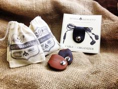 two pieces of leather sitting on top of a couch next to a book and bag