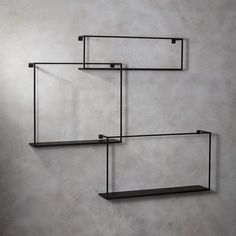 three black shelves are hanging on the wall