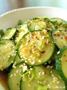 a white bowl filled with cucumbers and sesame seeds