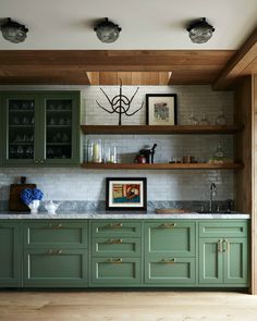 a kitchen with green cabinets and wooden shelves