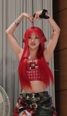 a woman with red hair is posing in front of a fan