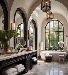 a large bathroom with arched windows and an oval tub in the center, surrounded by marble flooring