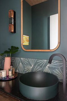 a bathroom sink with a mirror above it and a potted plant on the counter