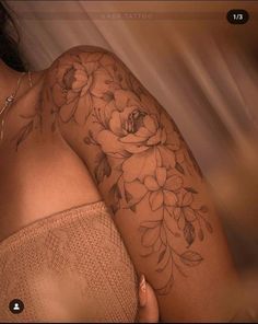 a woman's arm with flowers on it, and the back of her shoulder