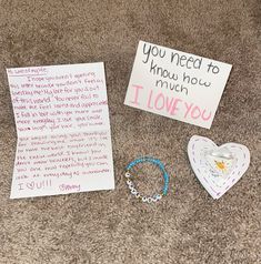 two pieces of paper, bracelets and a note on the floor next to each other