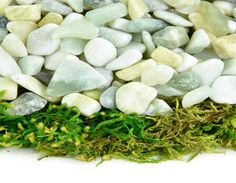 green moss and white rocks on top of each other with small stones in the middle