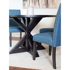 a dining room table with two blue chairs