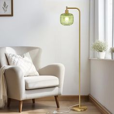 a living room with a chair, lamp and pictures on the wall