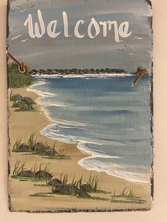 a welcome sign hanging on the side of a wall