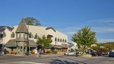 an intersection with cars and people walking on the sidewalk