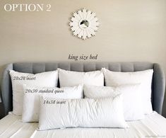 a bed with white pillows and a clock on the wall