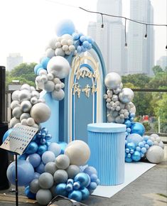 a blue and white arch decorated with balloons