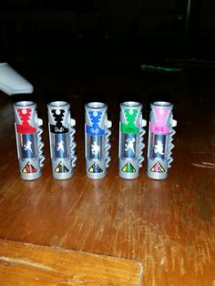 six different colored cans sitting on top of a wooden table