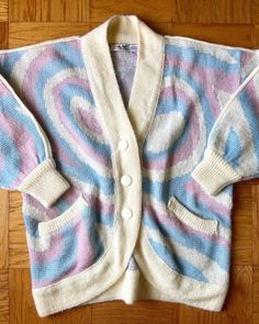 80's cotton candy swirl wool-blend cardigan by Lindsay Scott  How cute! Acrylic, wool, polyester blend in ivory, baby pink, and baby blue. Super chunky and oversized with batwing sleeves and a curved hem. Oversized plastic buttons, piping on the shoulders and down the sleeves, front pockets. Great condition, no notable flaws. A rare find!! Tagged a Large. 56"-62" bust, approx 30" length, 20" sleeve (but it does have a drop shoulder, true sleeve length around 24"), 44"-48" bottom opening Oversized Retro Acrylic Sweater, Oversized Vintage Spring Cardigan, Oversized Vintage Cardigan For Spring, Oversized Vintage Knit Cardigan, Retro Cream Sweater For Spring, Vintage Winter Sweater For Loungewear, Retro Winter Sweater For Loungewear, Oversized Vintage Cream Sweater, Pastel Cotton Candy