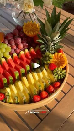 a bowl filled with fruit on top of a wooden table