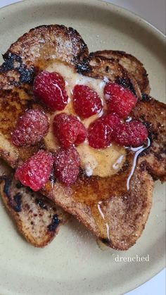 two pieces of french toast with raspberries on top