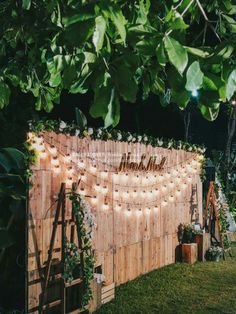 a wooden fence covered in lights and greenery