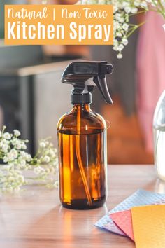 a brown glass bottle with a sprayer on top of it next to some flowers