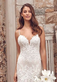 a woman in a wedding dress holding flowers