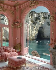 an ornate living room with pink walls and floor to ceiling windows looking out onto the ocean