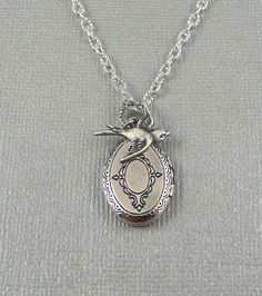 Oval shaped sweet and romantic necklace is 30 inches long. Burnish antique silver oval locket is engraved on both sides, with Victorian style different patterns/motifs. I have accented the locket with sterling silver plated swallow sparrow charm. Necklace is hanging from silver chain and silver lobster clasp. Locket is 21x16mm in size. It opens sideway and has room for two photos! Thanks for looking:) ~Mani Silver Oval Jewelry For Vintage Collection, Antique Silver Locket Necklace With Vintage Charm For Memorial, Silver Locket Necklace With Vintage Charm For Memorial, Vintage Silver Oval Pendant Locket Necklace, Antique Silver Oval Locket Necklace, Antique Silver Engraved Locket Necklace For Memorial, Silver Victorian Locket Necklace With Oval Pendant, Ornate Oval Locket Necklace From Vintage Collection, Silver Oval Locket Necklace Nickel Free