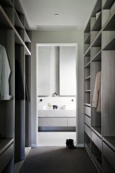 a walk in closet with white cabinets and drawers