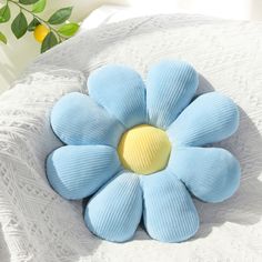 a blue flower sitting on top of a white blanket