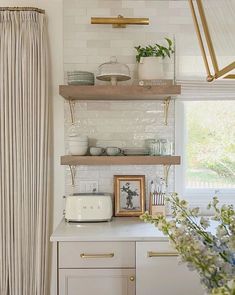 a kitchen with open shelving and white walls