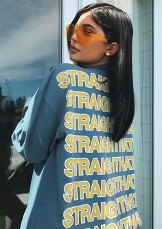 a woman standing in front of a window wearing a t - shirt with words on it