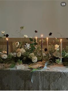 a table topped with lots of flowers and candles