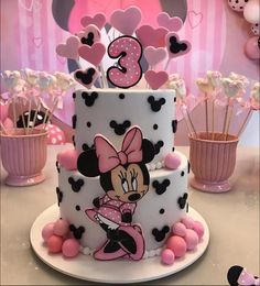 a minnie mouse birthday cake with pink and black decorations