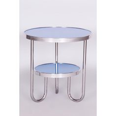 a round glass table with metal legs and a blue top on a white background is shown