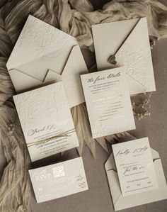 the wedding stationery is laid out on top of each other, with matching envelopes