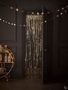 a black room with gold stars hanging from the ceiling and a round table in front of it